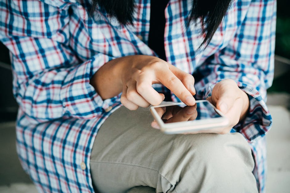 pexels-photo-367273-367273 Woman's hands using a smartphone, wearing plaid shirt, indoors. Close-up shot highlighting touch interaction.